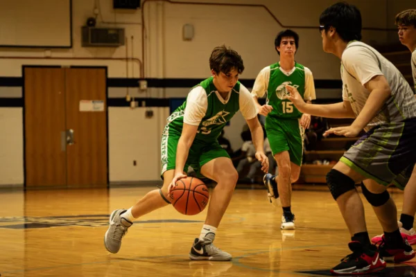 A group of young men playing basketball on a court.